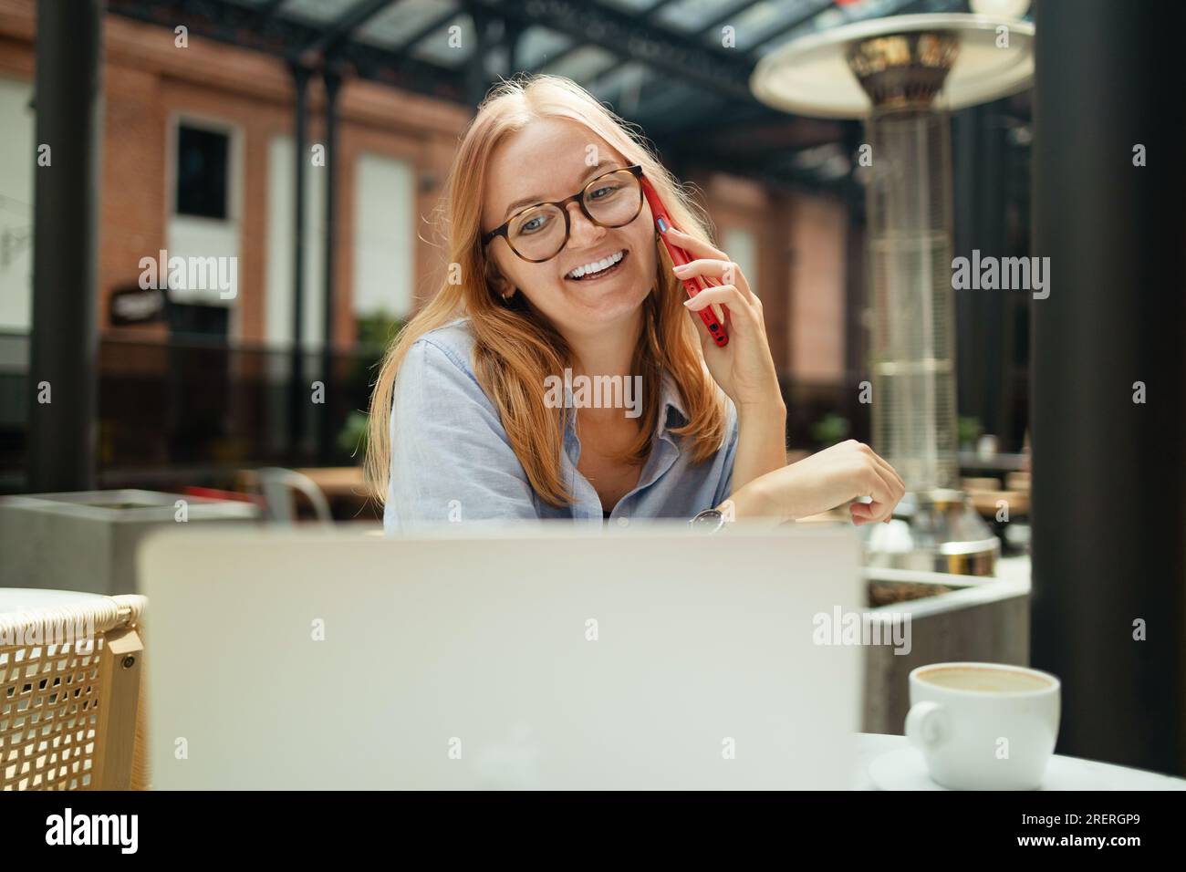 Young smiling Caucasian woman student calling with cell telephone while ...
