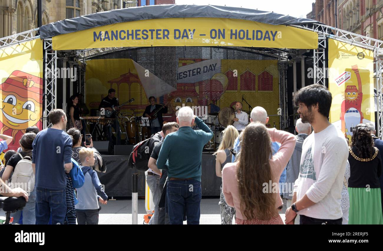 Manchester, UK, 29th July, 2023. The music stage on Deansgate with the road fully blocked off,  where many artistes and bands performed to an appreciative crowd. Manchester Day - on Holiday!, free, fun, family friendly, events on the streets of city centre Manchester, UK. Supported by Manchester City Council, Manchester Airport Group, Biffa, The Co-op, Manchester Evening News, Walk the Plank, Kingdom of Sweets, British Firefighter Challenge and Capri Beach Club. Credit: Terry Waller/Alamy Live News Stock Photo