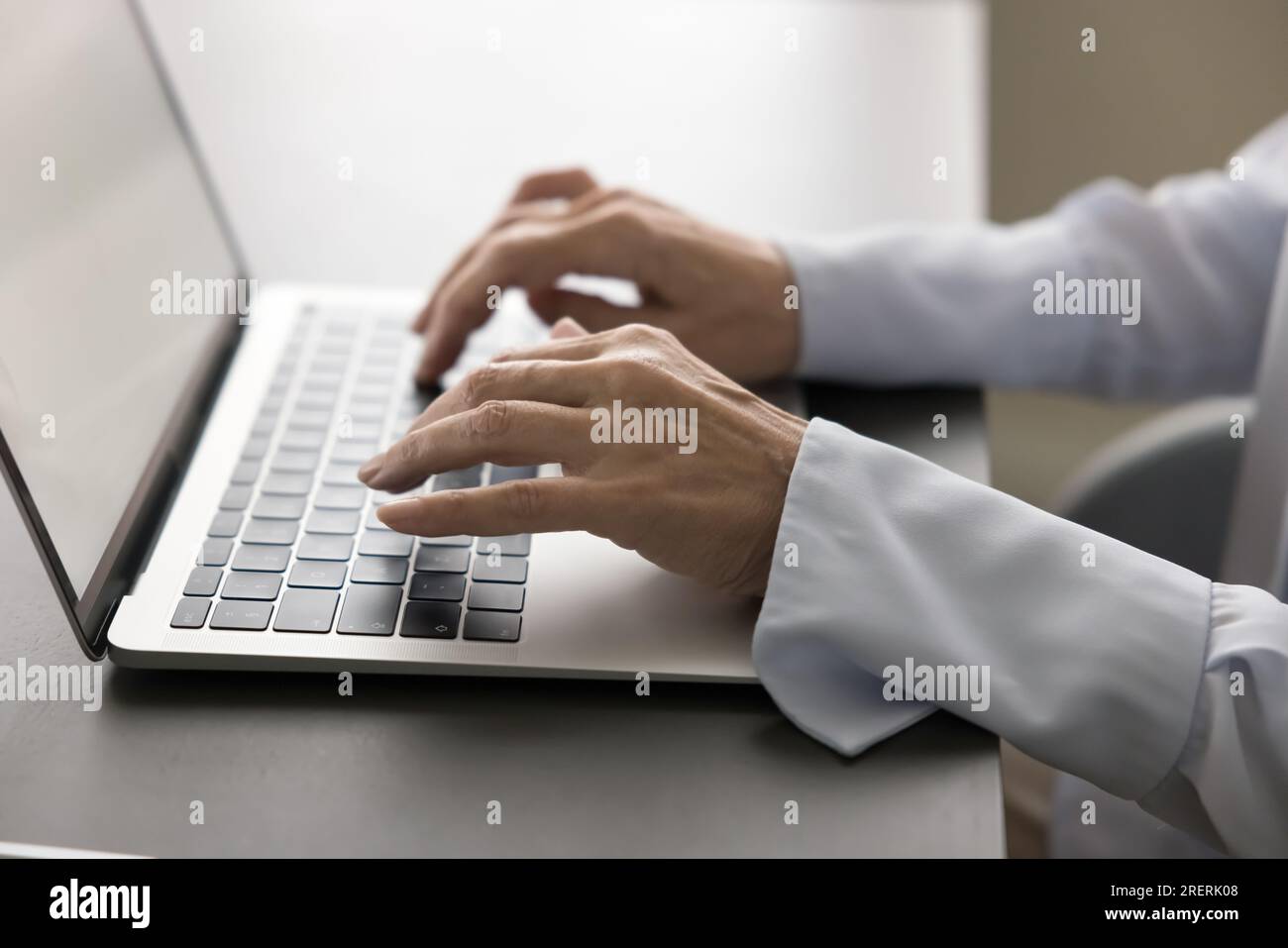Hands of mature businesswoman typing on laptop keyboard Stock Photo