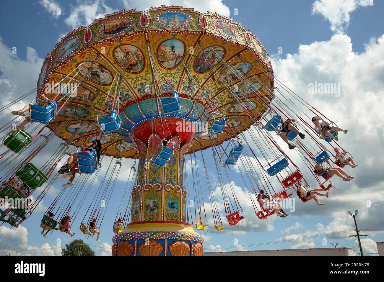 Fair goers enjoy a tilting swing ride on the midway at the 2023 Delaware State Fair, Harrington, Delaware USA. Stock Photo