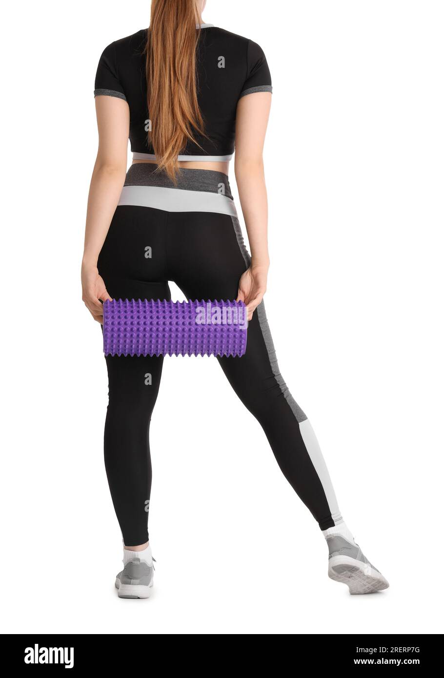 Young woman in sportswear and with foam roller on white background ...