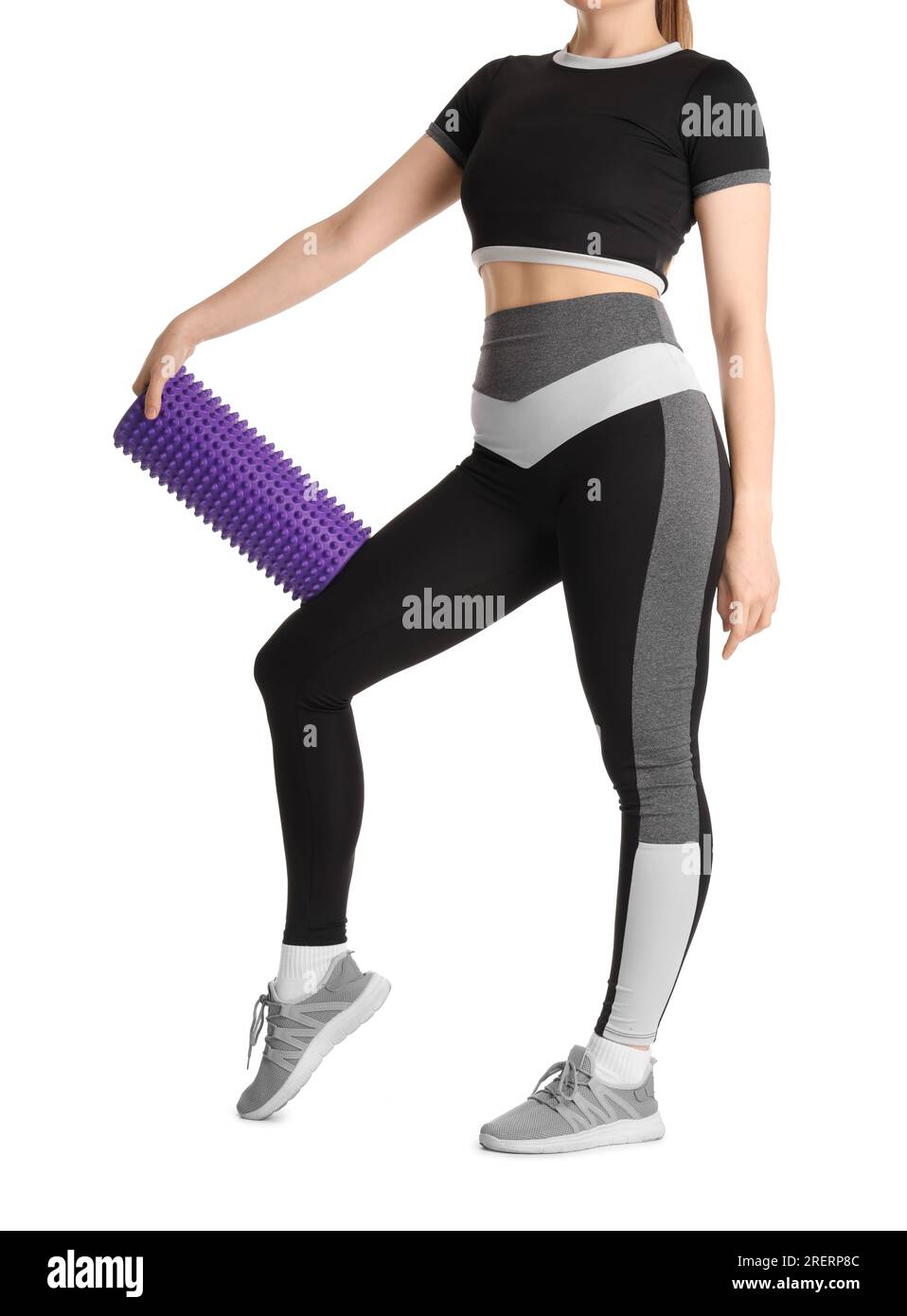 Young woman in sportswear and with foam roller on white background ...