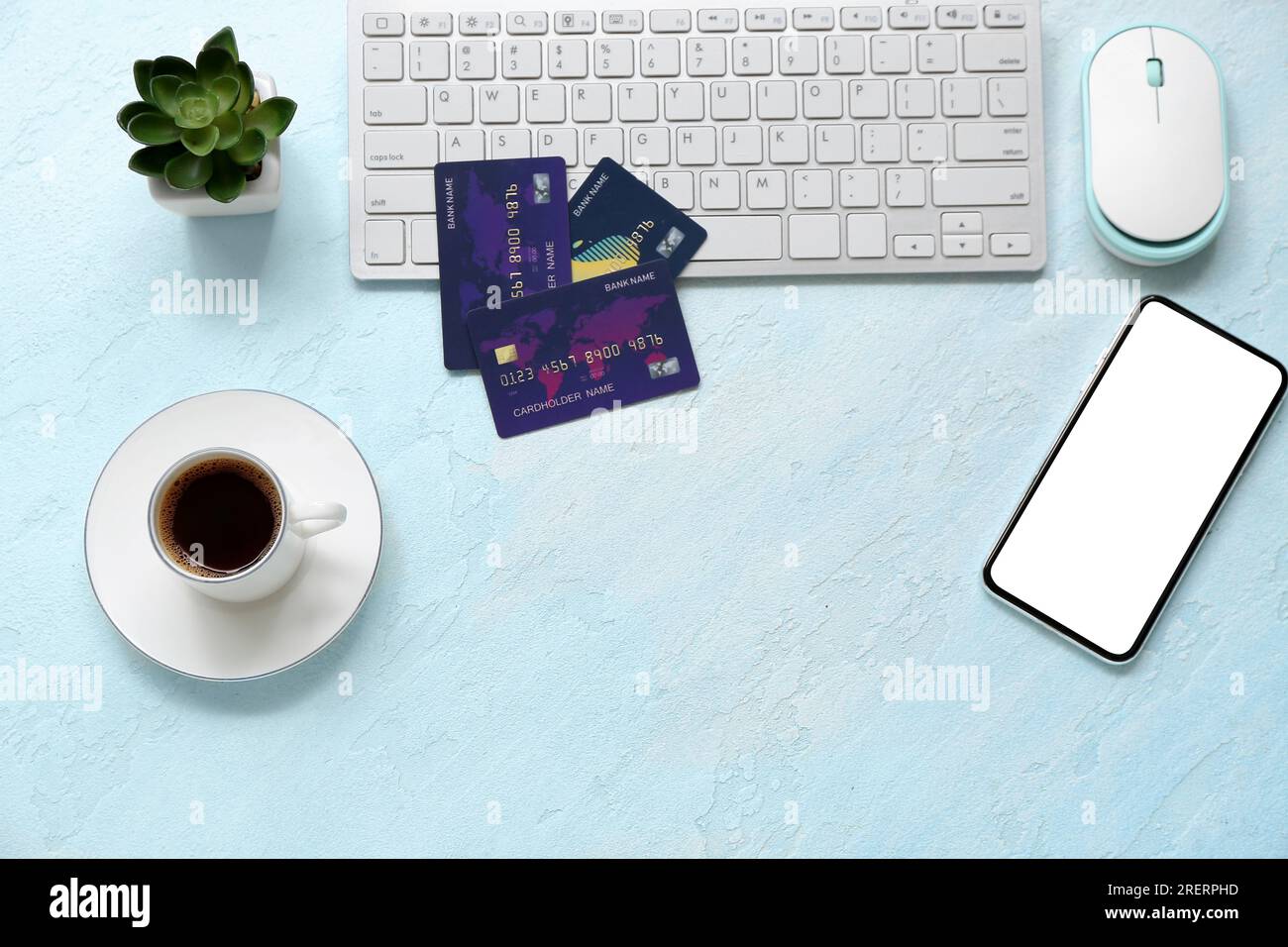 Keyboard with credit cards, mobile phone and cup of coffee on color background Stock Photo