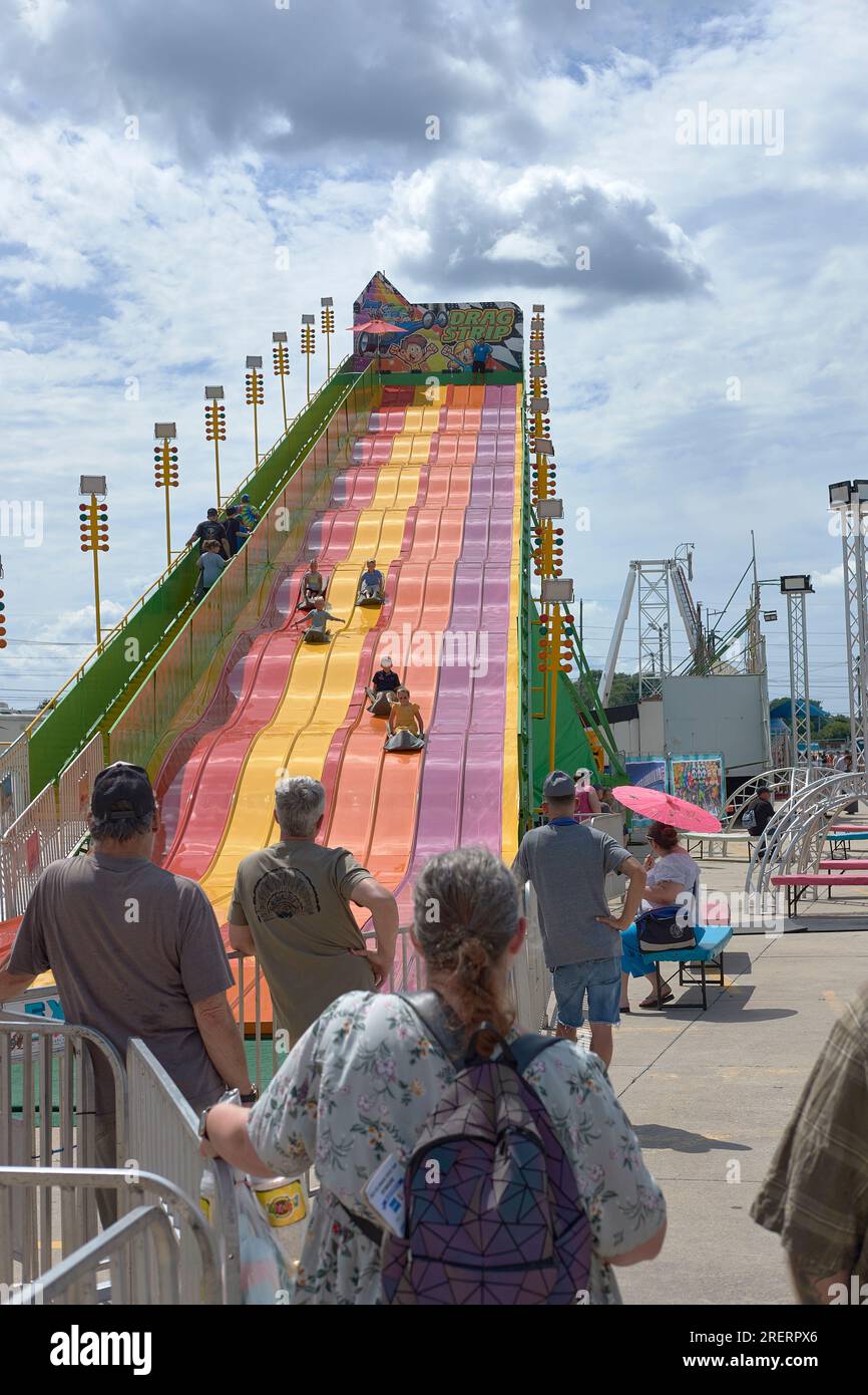 Visitors enjoy a sliding ride on the midway at the 2023 Delaware State Fair, Harrington, Delaware USA. Stock Photo