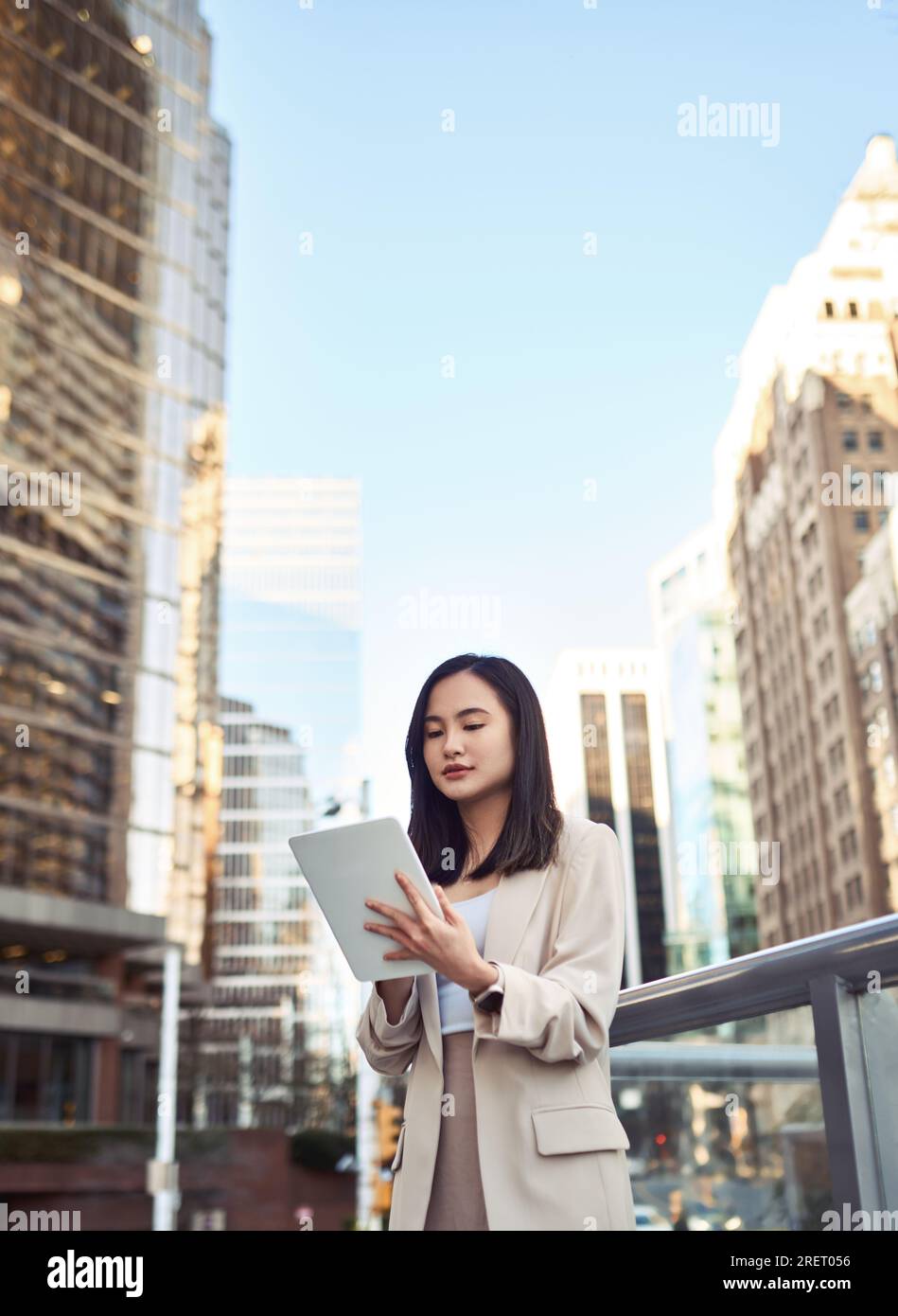 Young Asian business woman professional standing in city using tablet. Stock Photo