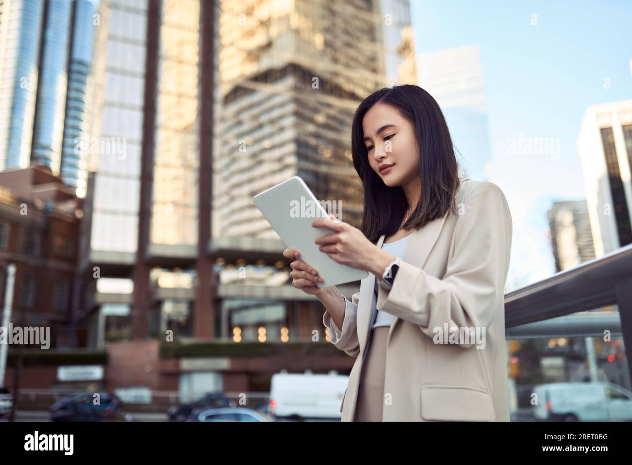 Young Asian business woman professional standing in city using digital tablet. Stock Photo