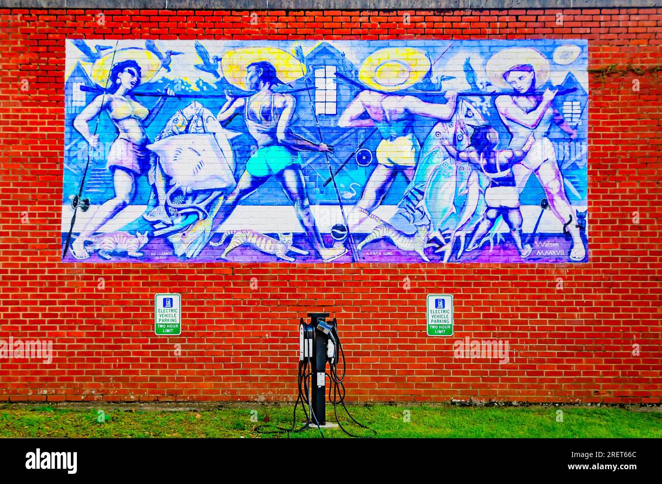 A mural is painted above an electric vehicle charging station at