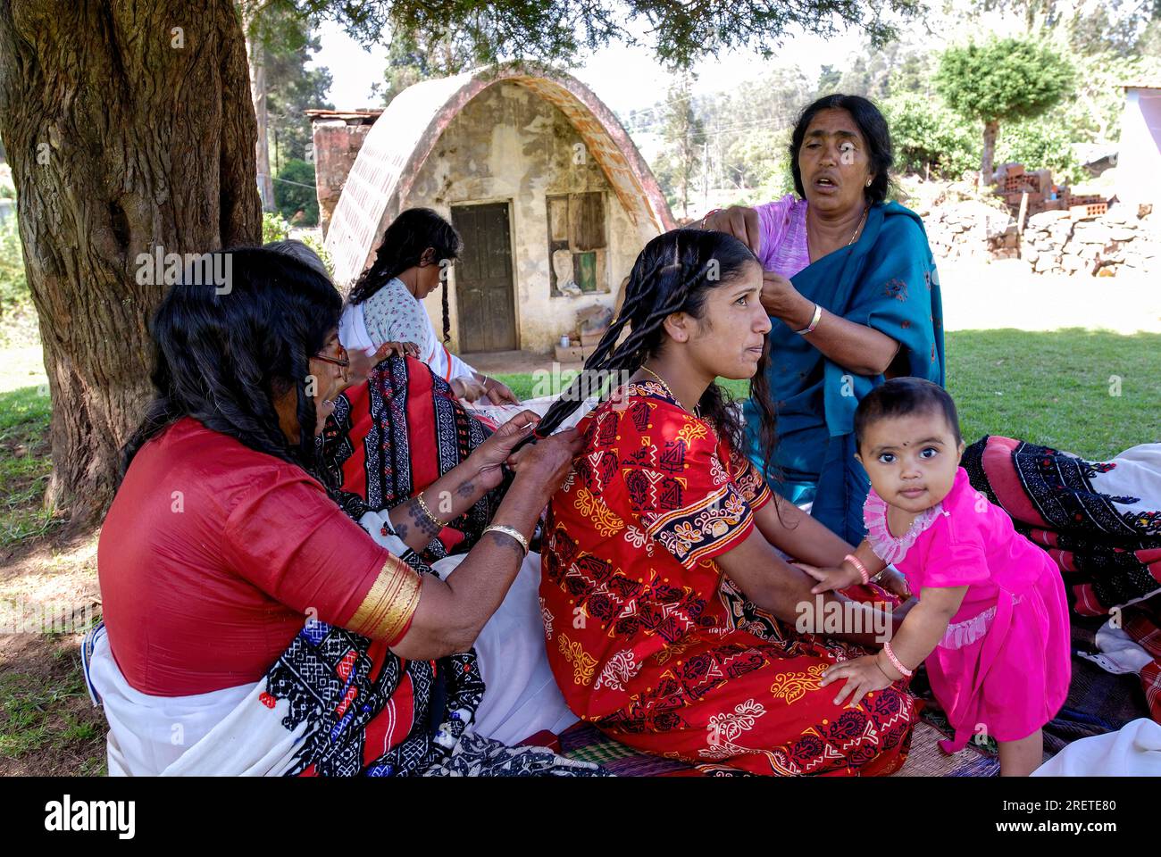 Toda women plaiting the bride's hair and making it curly with ghee
