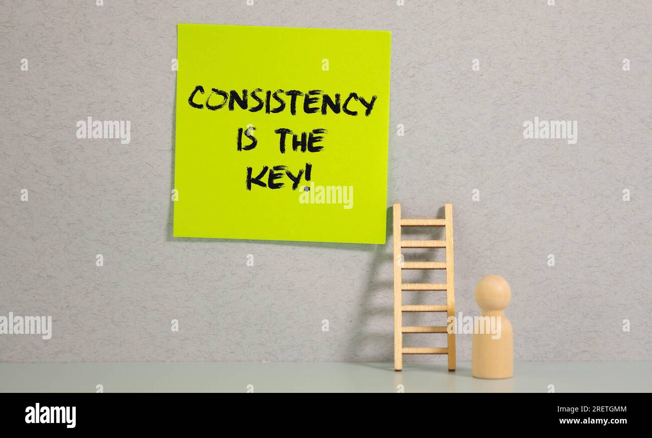 businesman hold notepad with text Consistency is the key. White ...