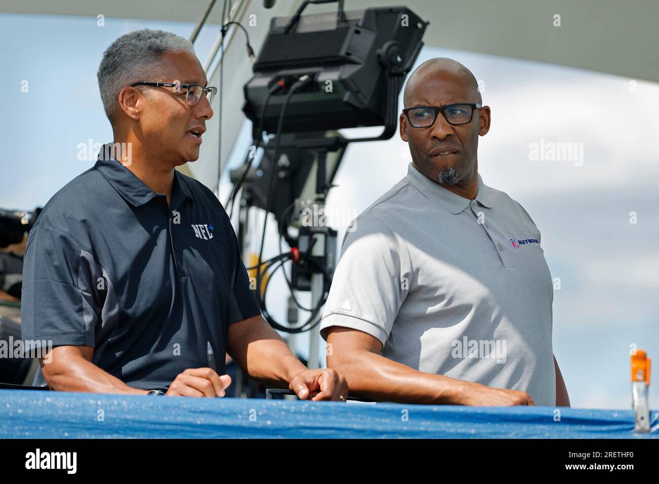 NFL network reporters Steve Wyche, left, and Bucky Brooks watch as the Minnesota Vikings practice during an NFL football practice Saturday, July 29, 2023, in Eagan, Minn