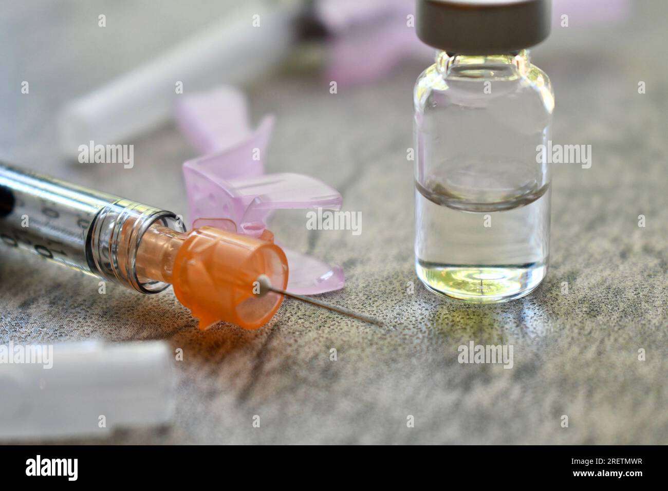 Vial of medicine with syringe on a grey surface Stock Photo