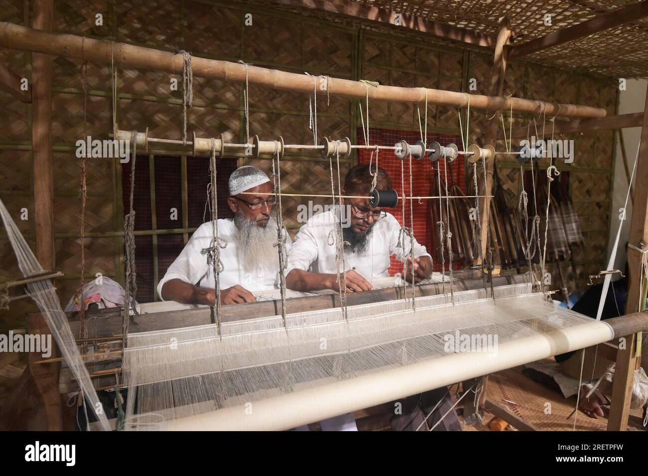 Dhaka. 30th July, 2023. Weavers make the Jamdani saree (women's garment) on a loom during a festival in Dhaka, Bangladesh on July 29, 2023. In an attempt to restore the glorious past of Jamdani, Bangladesh has organized an 11-day festival titled 'Wearable Art Jamdani Festival' in capital Dhaka from July 19 to highlight the textile here. Credit: Xinhua/Alamy Live News Stock Photo