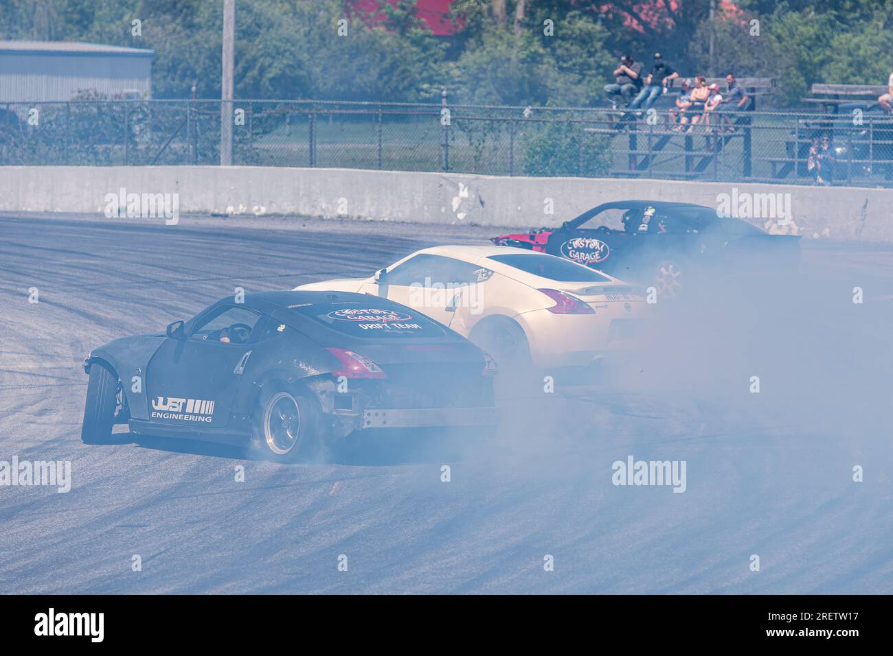 Car drifting auto racing event action with smoking tires - burning tires on the track in motion. Sanair Superspeedway, Canada, Quebec Stock Photo