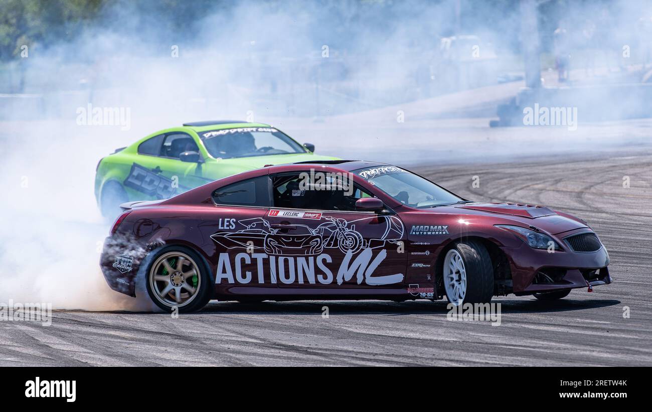 Car drifting auto racing event action with smoking tires - burning tires on the track in motion. Sanair Superspeedway, Canada, Quebec Stock Photo