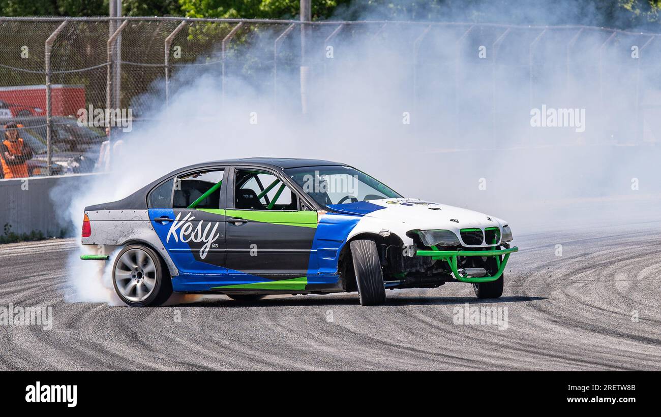 Car drifting auto racing event action with smoking tires - burning tires on the track in motion. Sanair Superspeedway, Canada, Quebec Stock Photo