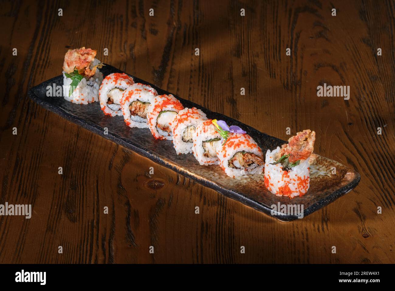 High angle of served Japanese uramaki set with tobiko fish roe and