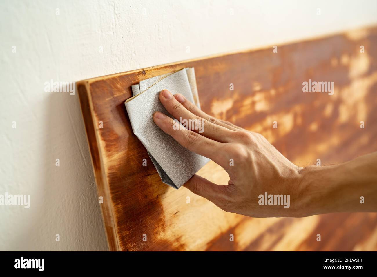 Scrubbing wood panel with sandpaper Stock Photo