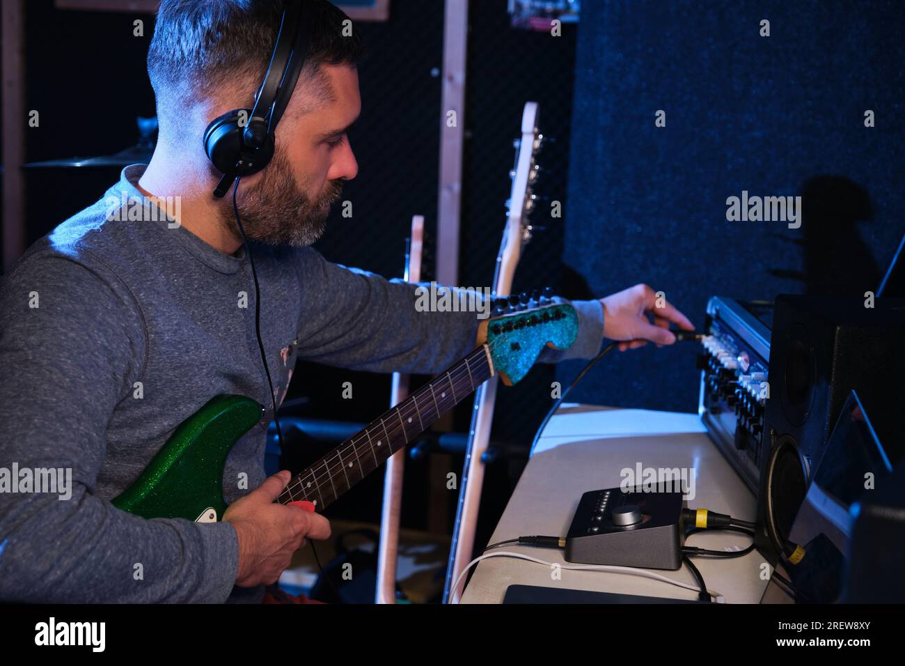 Musician connecting his electric guitar to a mixing console Stock Photo