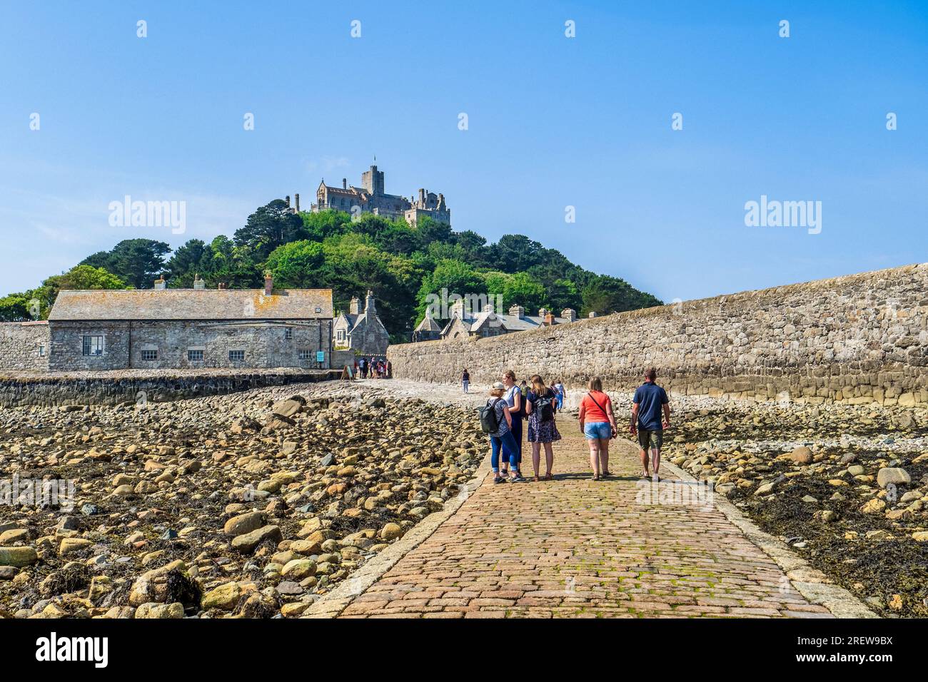 14 June 2023: Marazion, Cornwall, UK - Visitors walking on the causeway to St Michael's Mount, on a beautiful summer day. Stock Photo
