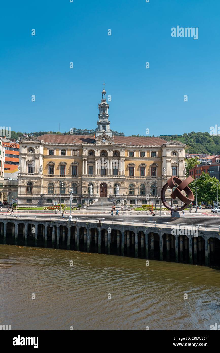 Beautiful City Hall building of the Bilbao city, built in Baroque style. In front of the building is the river Nervion. People passing. Stock Photo