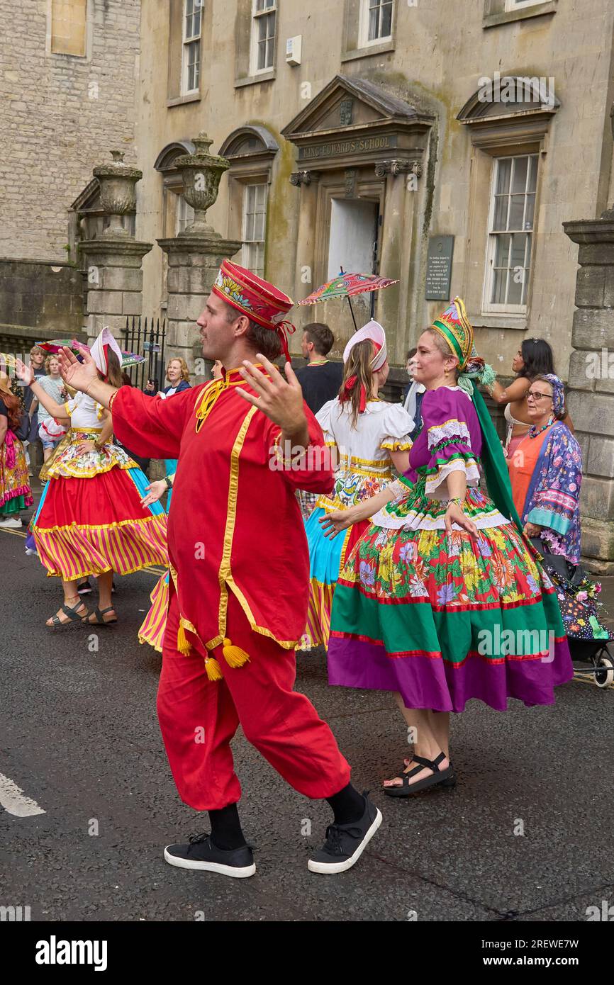 Dancers and musicians dressed in ornate costumes parade through the