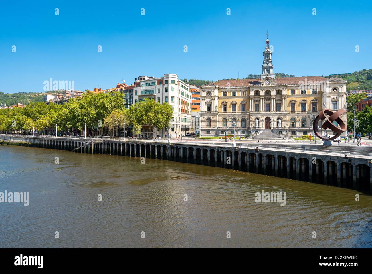 Beautiful City Hall building of the Bilbao city, built in Baroque style. In front of the building is the river Nervion. People passing. Stock Photo