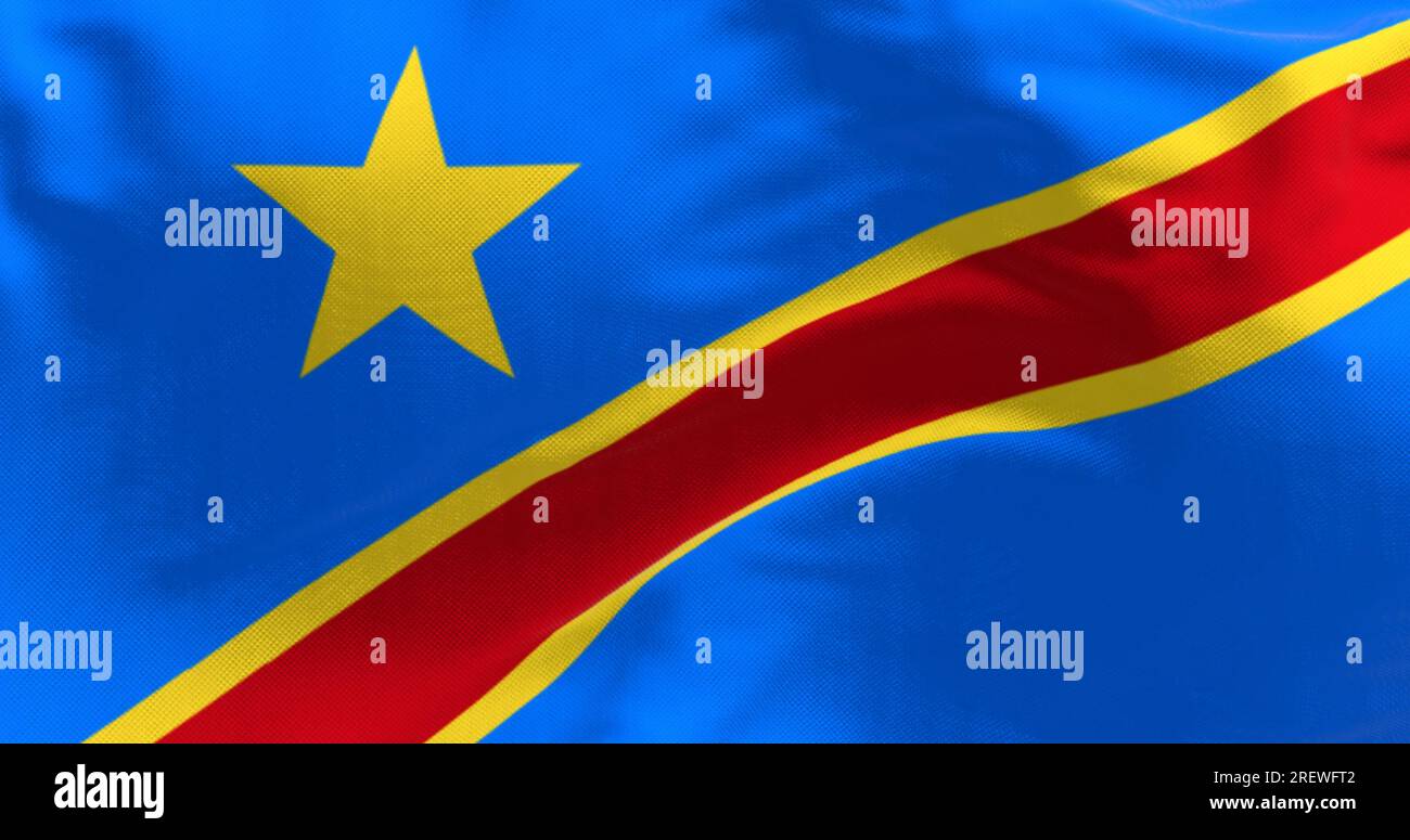 Close-up of Democratic Republic of the Congo national flag waving. Sky blue flag with yellow star in upper left corner. Diagonal red stripe with yello Stock Photo