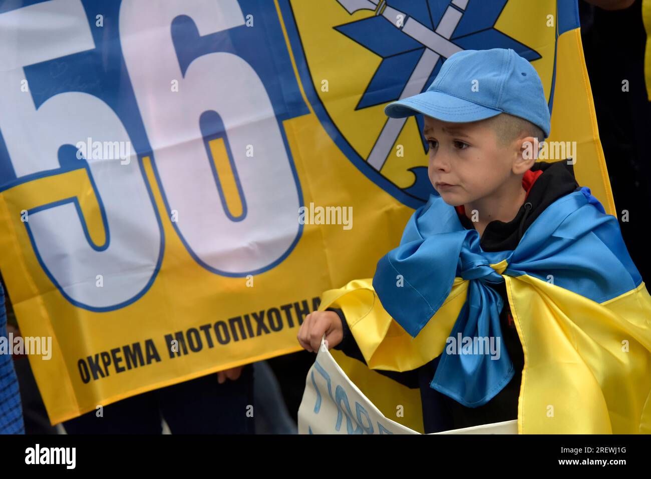 Non Exclusive: VINNYTSIA, UKRAINE - JULY 27, 2023 - A little boy wrapped in a Ukrainian flag holds a placard reading &#x91;Give Me Father Back&#x92; d Stock Photo