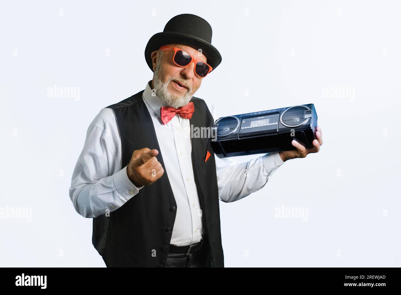 An elderly man in an old classic suit with a cassette recorder from 80s. On a white background. Stock Photo