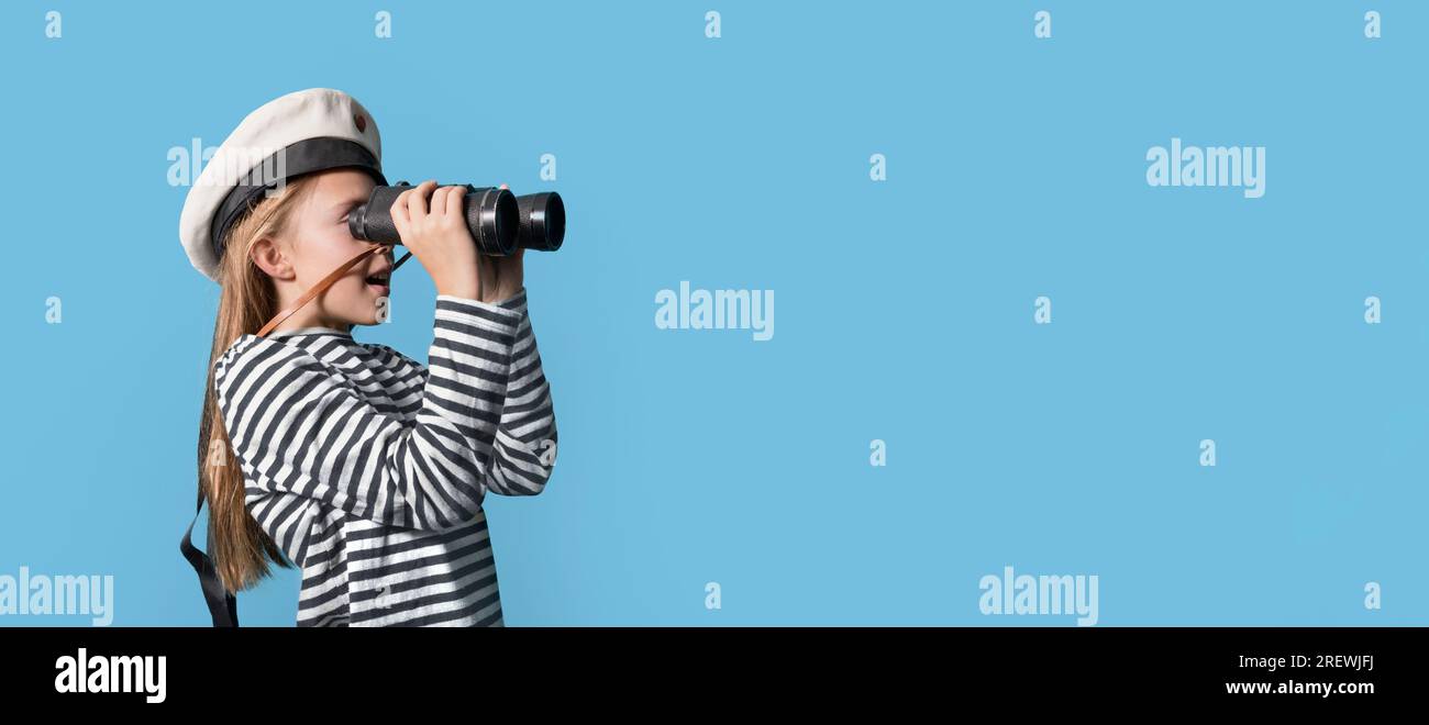 Banner-portrait of a sailor girl on a blue background teenage girl in a sailor suit with a binocular looking into the distance Stock Photo