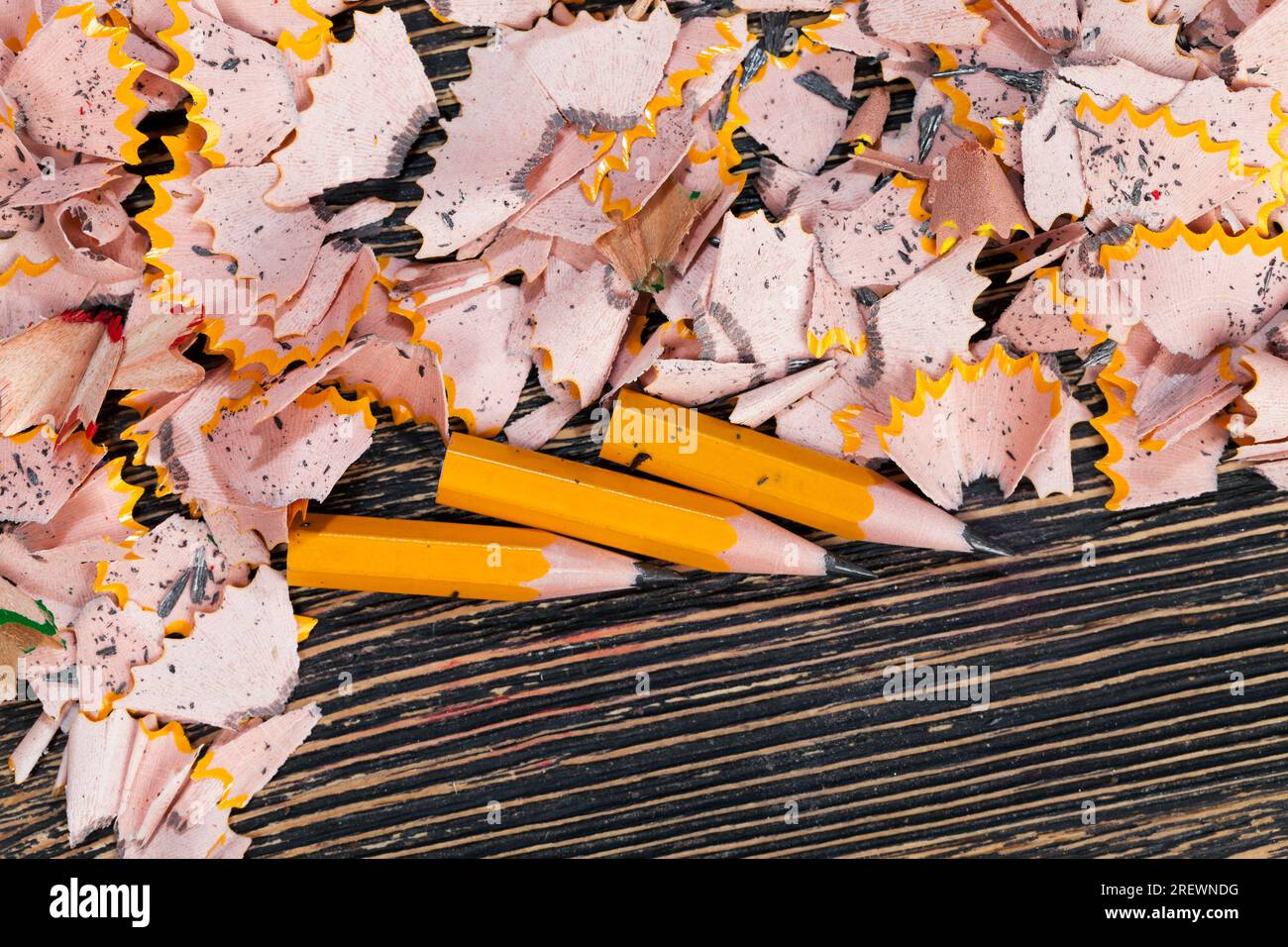 pencil shavings after sharpening, wood debris and parts of pencil lead