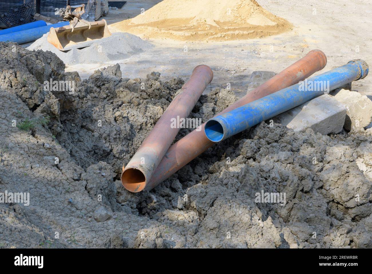 The plastic pipes of large diameter for building water communications at the construction site in brown and blue Stock Photo