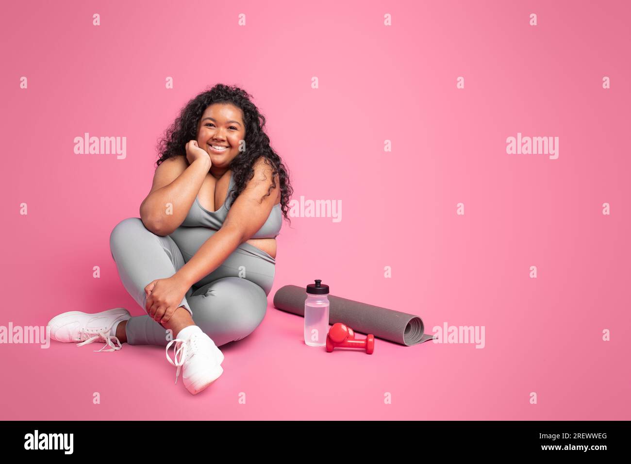 Recovery after workout training. Happy black body positive woman resting on  floor over pink background, free space Stock Photo - Alamy