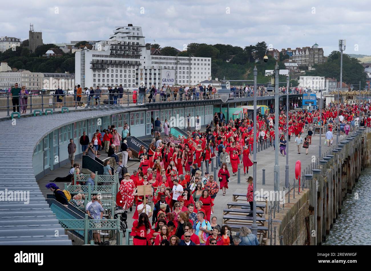 People dressed in red arrive to take part in a mass dance event to Kate