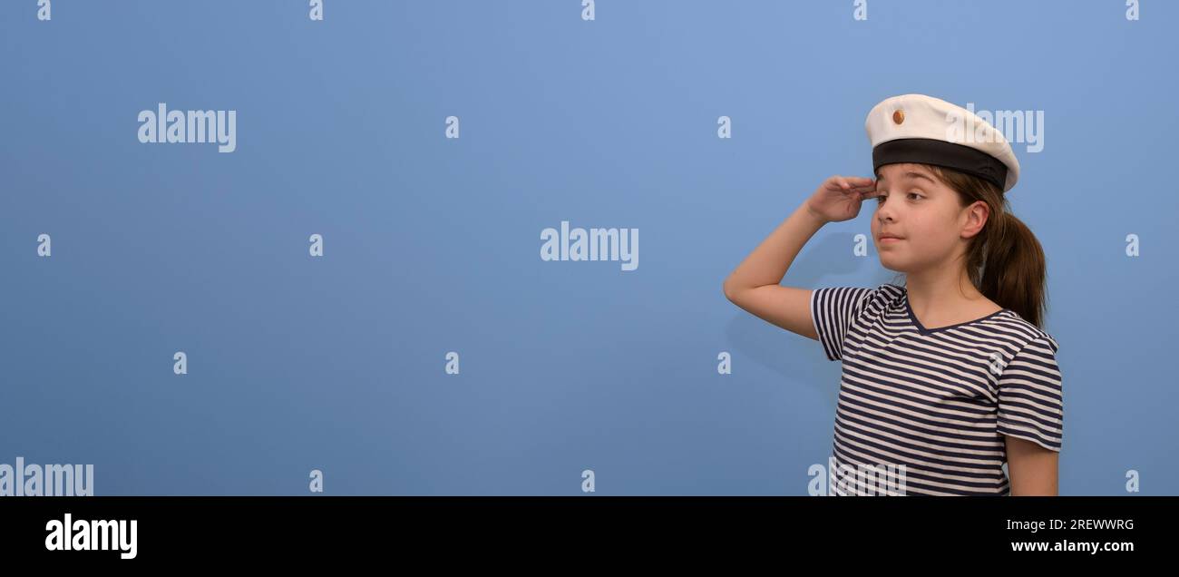 Banner of a sailor girl on a blue background. Teenage girl in a sailor suit with a sailor salutes Stock Photo