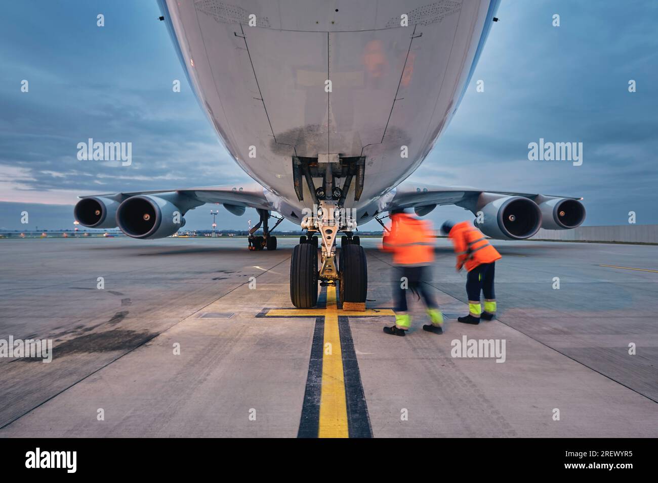 Low angle view of freight airplane. Ground staff at airport. Preparation cargo plane before flight during sunny day. Stock Photo