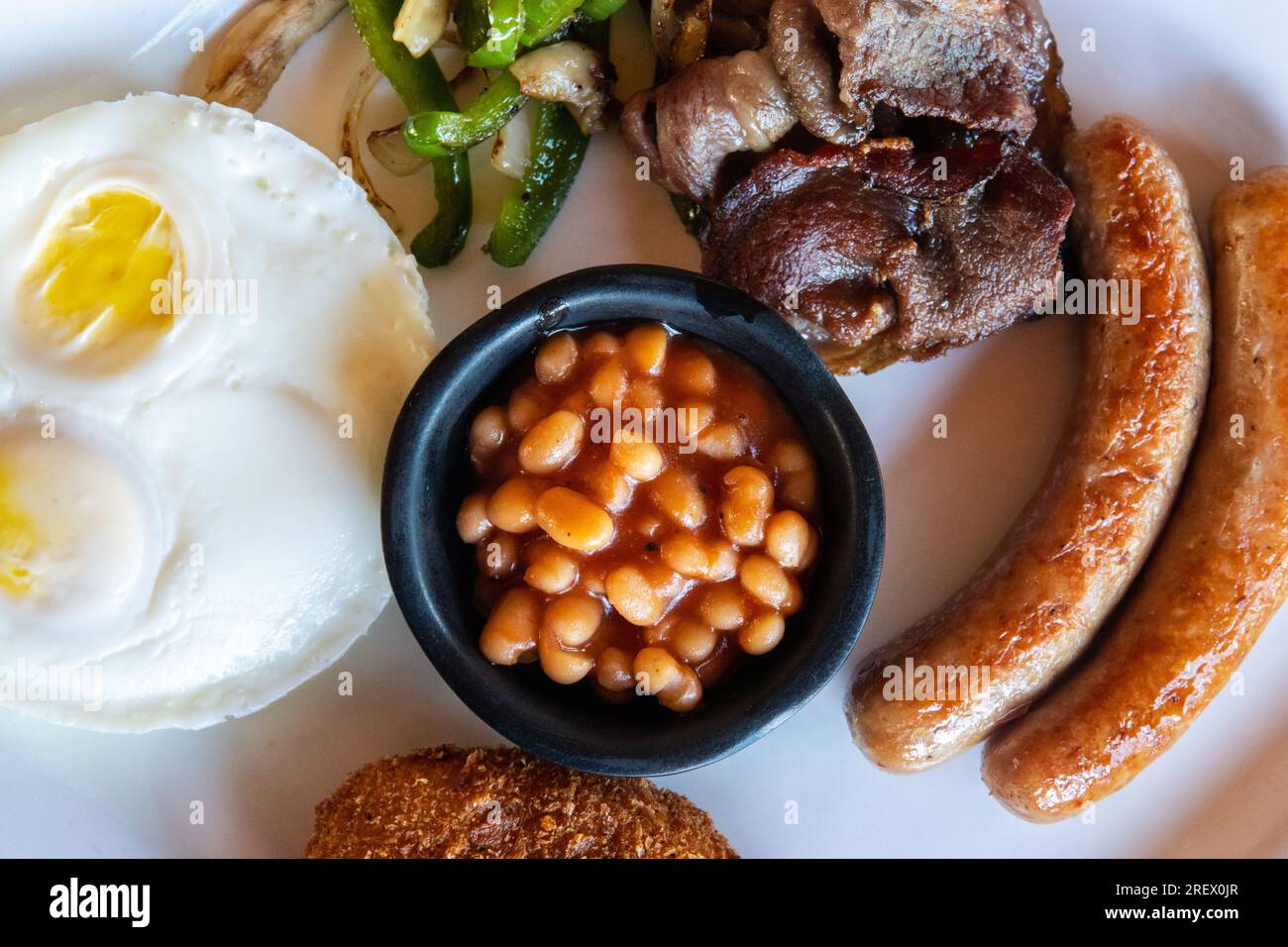 American Breakfast with Eggs, Sausages, Bacon, Beans, Hash Brown Potatoes and Sauted Vegetables Stock Photo