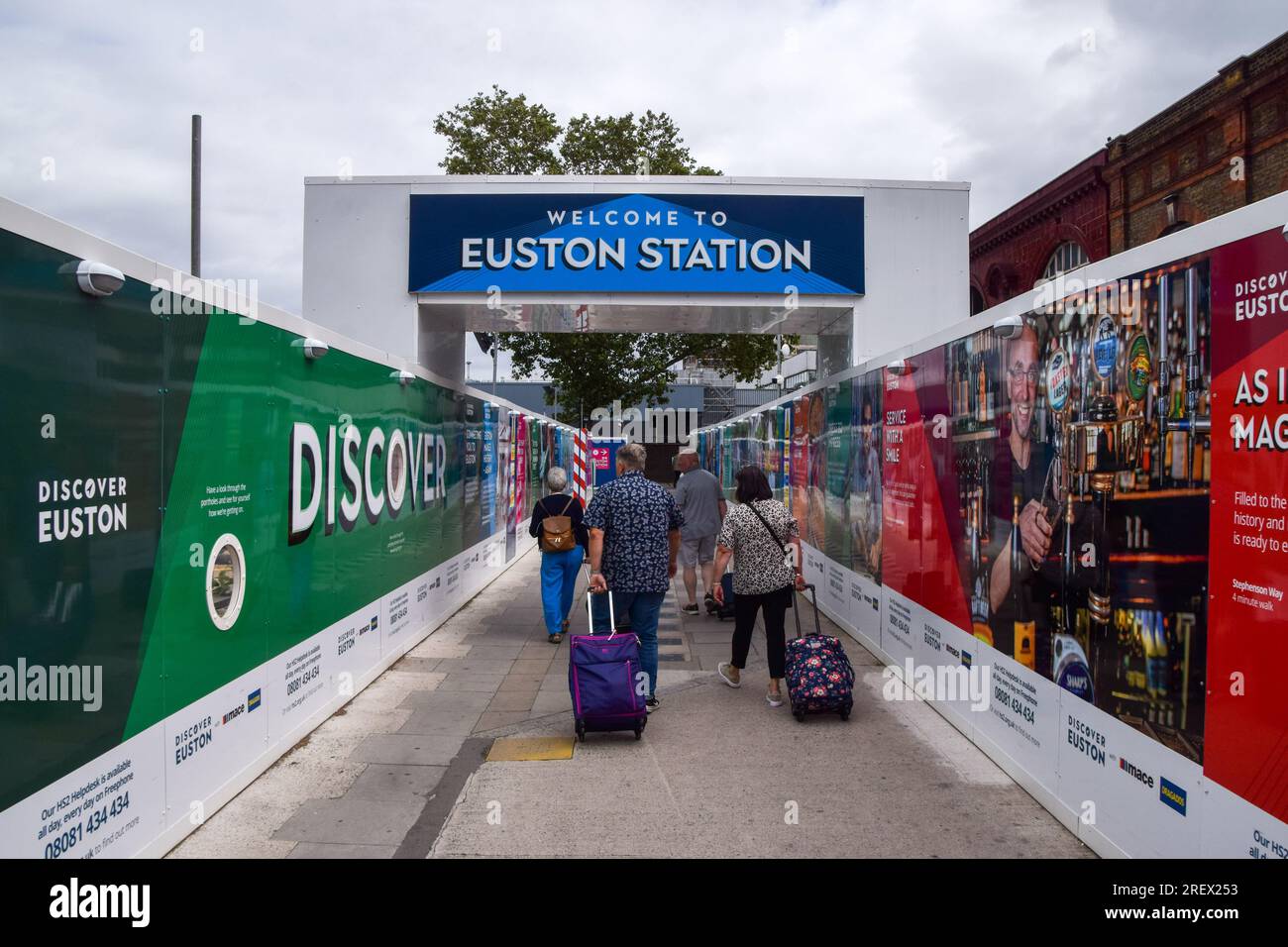 London, England, UK. 30th July, 2023. Travellers walk past the HS2 construction site at Euston station. The High Speed 2 rail line has been given an ''unachievable'' rating by the Infrastructure and Projects Authority. (Credit Image: © Vuk Valcic/ZUMA Press Wire) EDITORIAL USAGE ONLY! Not for Commercial USAGE! Stock Photo