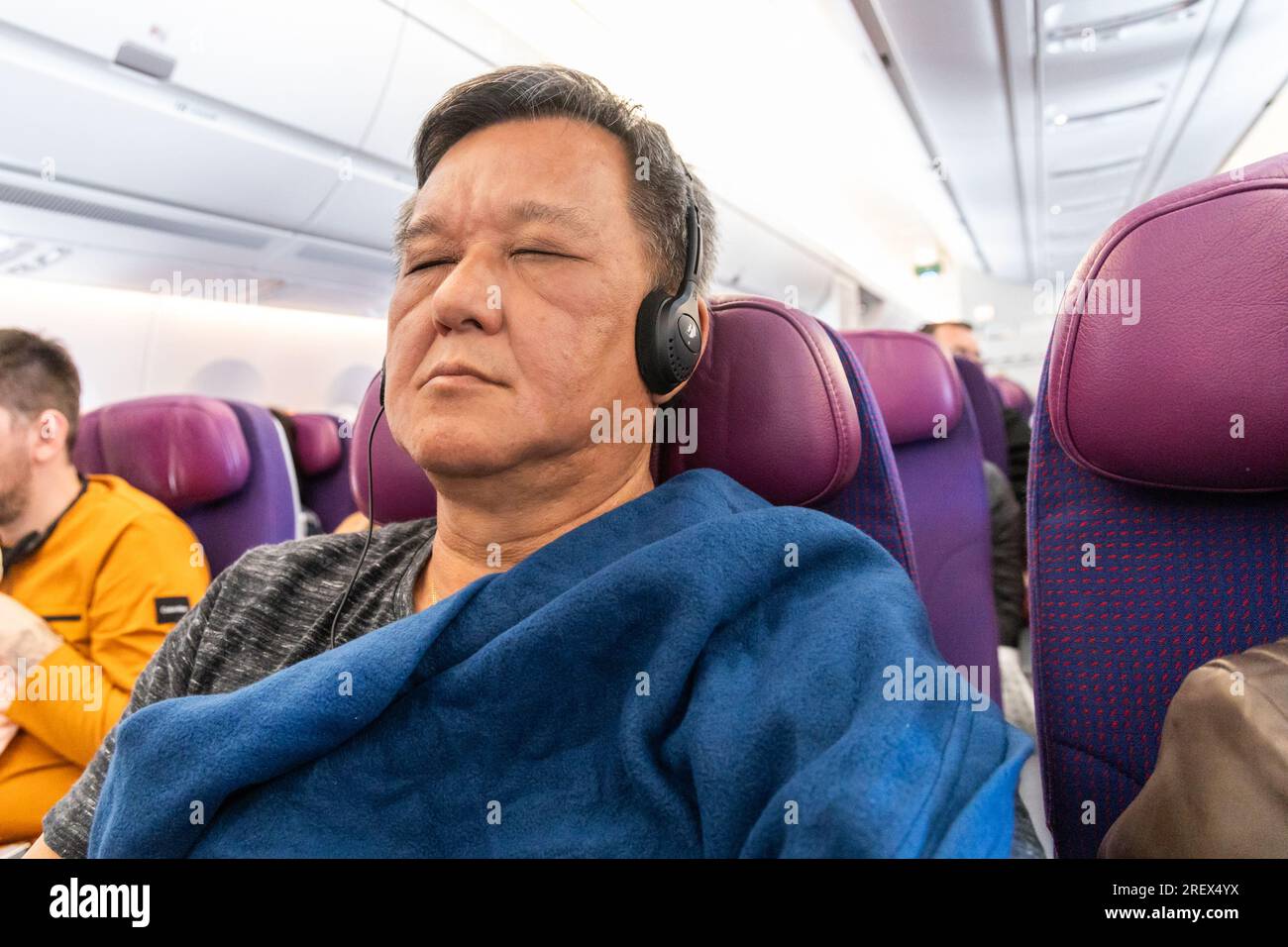 Passenger cover himself with wool blanket provided by airline during