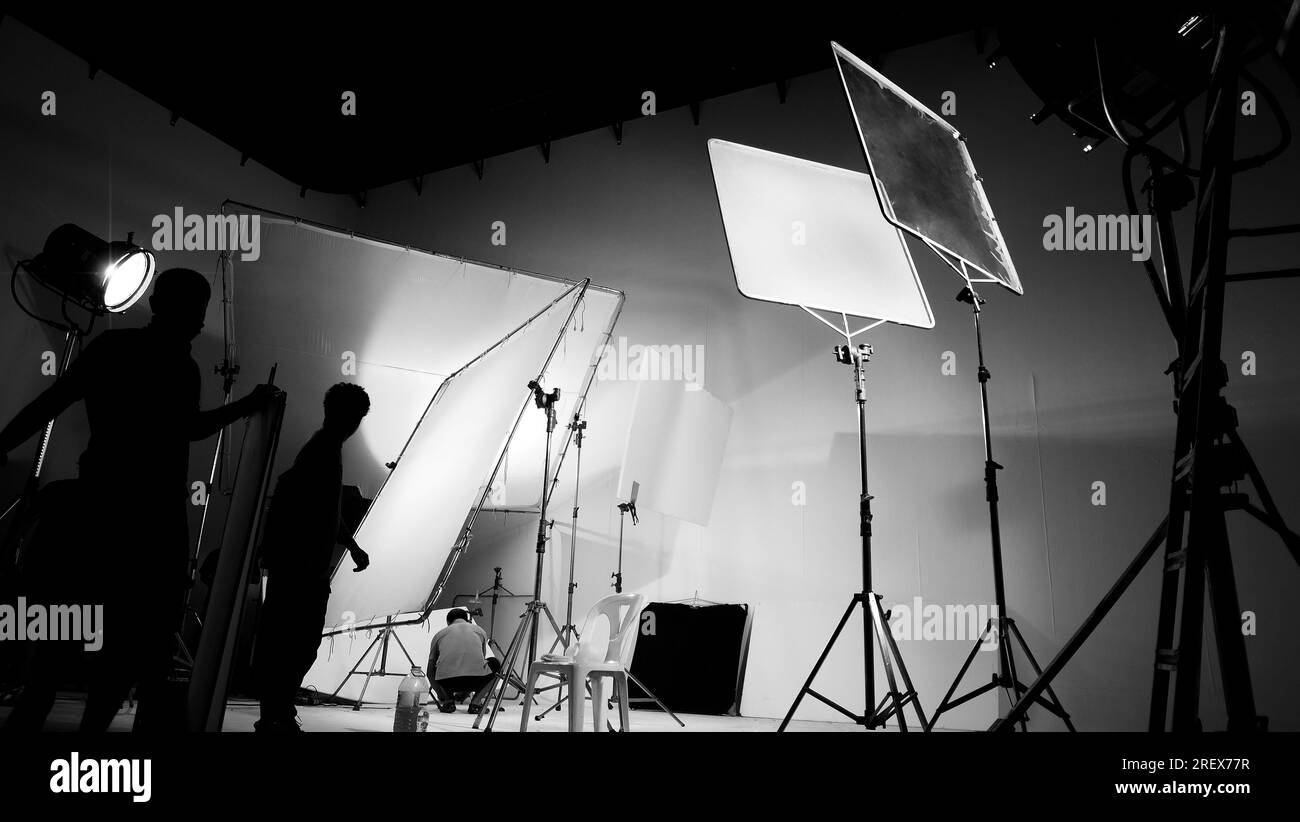 Silhouette of video production behind the scenes or B roll or making of TV commercial movie that film crew team lightman and cameraman working togethe Stock Photo