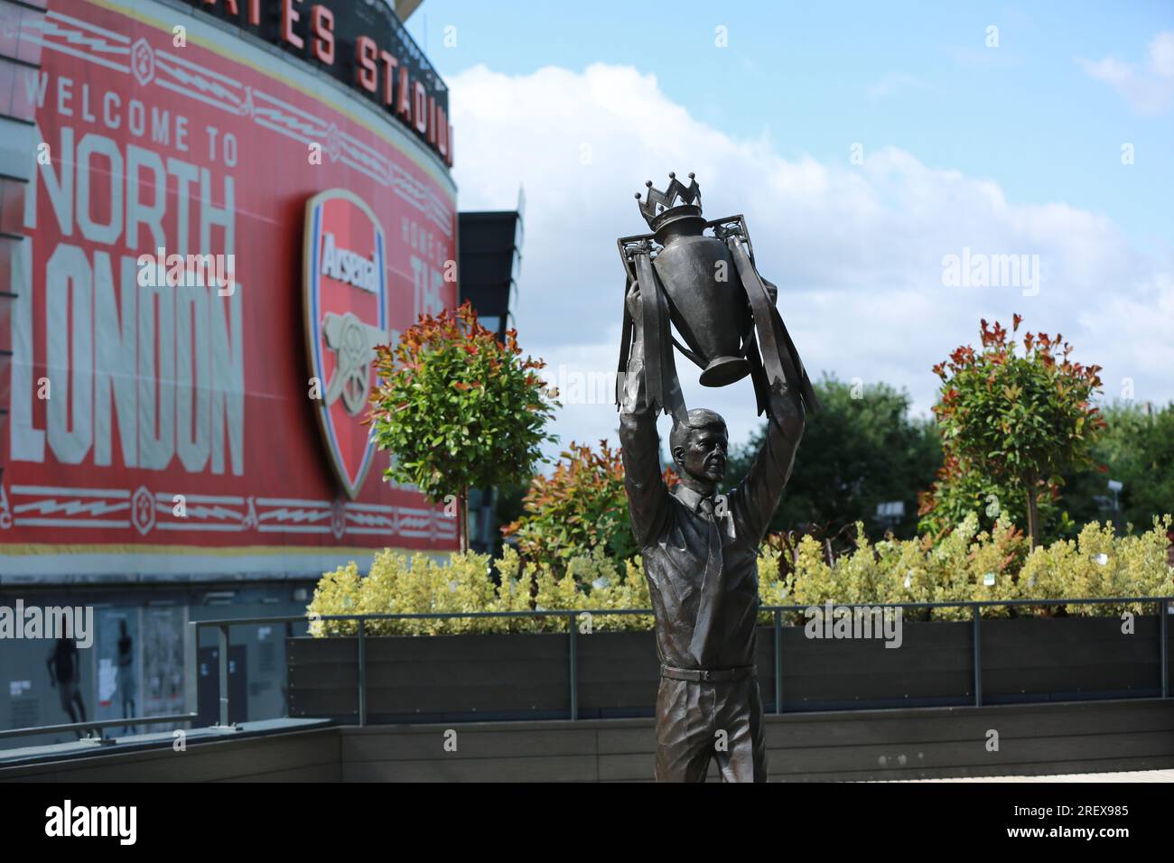 London, UK. 30 July 2023. Arsenal unveil Arsène Wenger statue outside the Emirates Stadium to commemorate the Gunners iconic manager's 22-year tenure at the club. The legendary manager led Arsenal FC to three Premier League titles, including the famous Invincibles season in 2003/04 where his side remained unbeaten, and seven FA Cups. The bronze statue, which was created by sculptor Jim Guy, is 3.5 metres high and weighs approximately half a tonne, and depicts the former French manager lifting the Premier League trophy. Credit: Waldemar Sikora/Alamy Live News Stock Photo