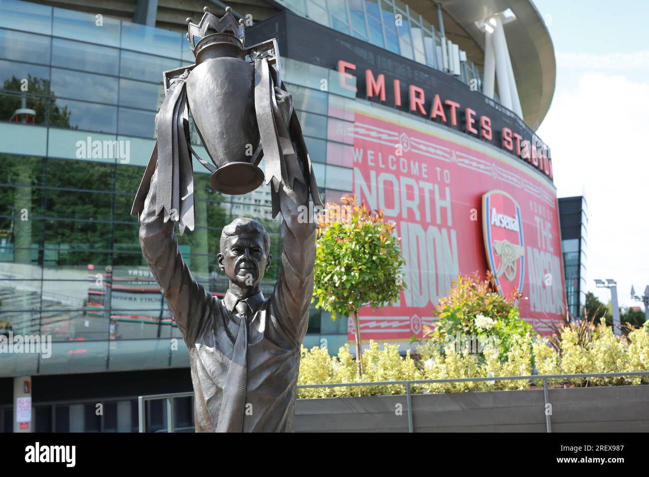 London, UK. 30 July 2023. Arsenal unveil Arsène Wenger statue outside the Emirates Stadium to commemorate the Gunners iconic manager's 22-year tenure at the club. The legendary manager led Arsenal FC to three Premier League titles, including the famous Invincibles season in 2003/04 where his side remained unbeaten, and seven FA Cups. The bronze statue, which was created by sculptor Jim Guy, is 3.5 metres high and weighs approximately half a tonne, and depicts the former French manager lifting the Premier League trophy. Credit: Waldemar Sikora/Alamy Live News Stock Photo