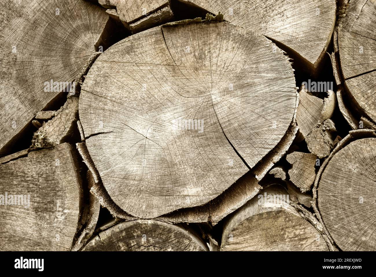 Chopped firewood is stacked in neat piles. Woodpile. Background, toned