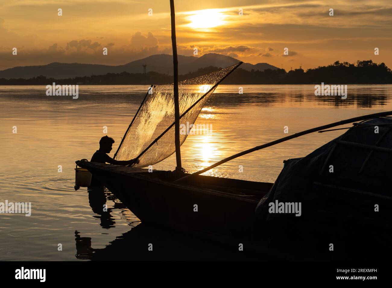 Guwahati, India. 30th July 2023. A fisherman fishing in the Brahmaputra river during sunset in