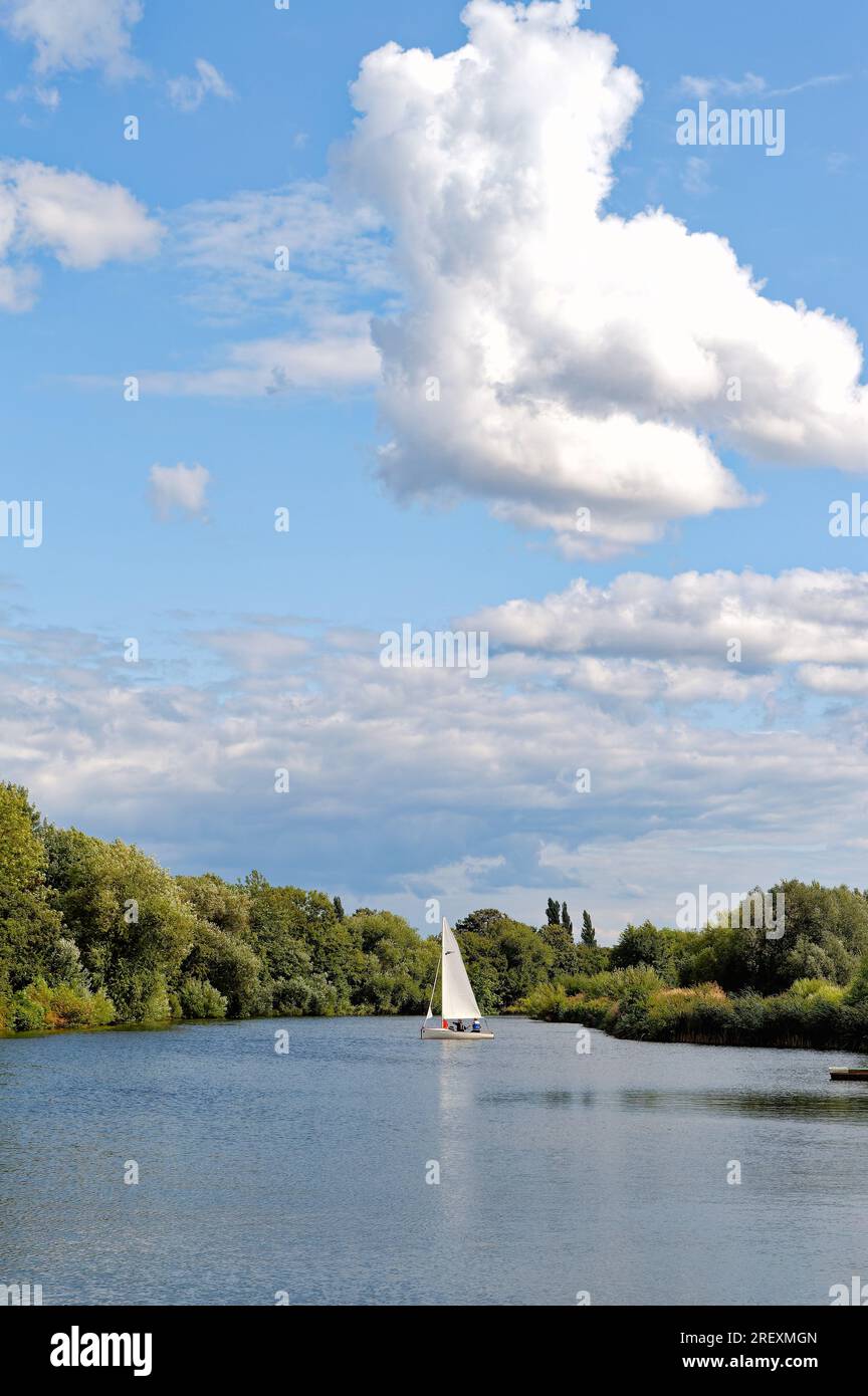 A small yacht sailing on the River Thames at Shepperton on a sunny summers day, Surrey England UK Stock Photo