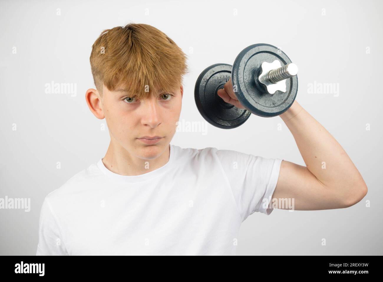 Portrait of a 14 year old caucasian teenage boy exercising with a dumbbell Stock Photo Alamy
