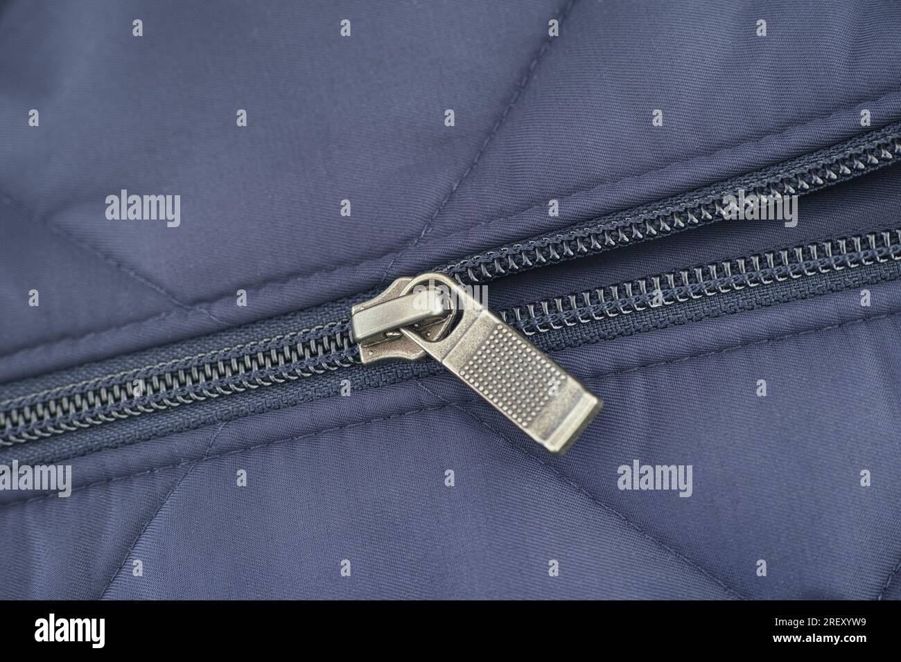 Closeup shot of a zipper on a blue jacket. Close up. Stock Photo