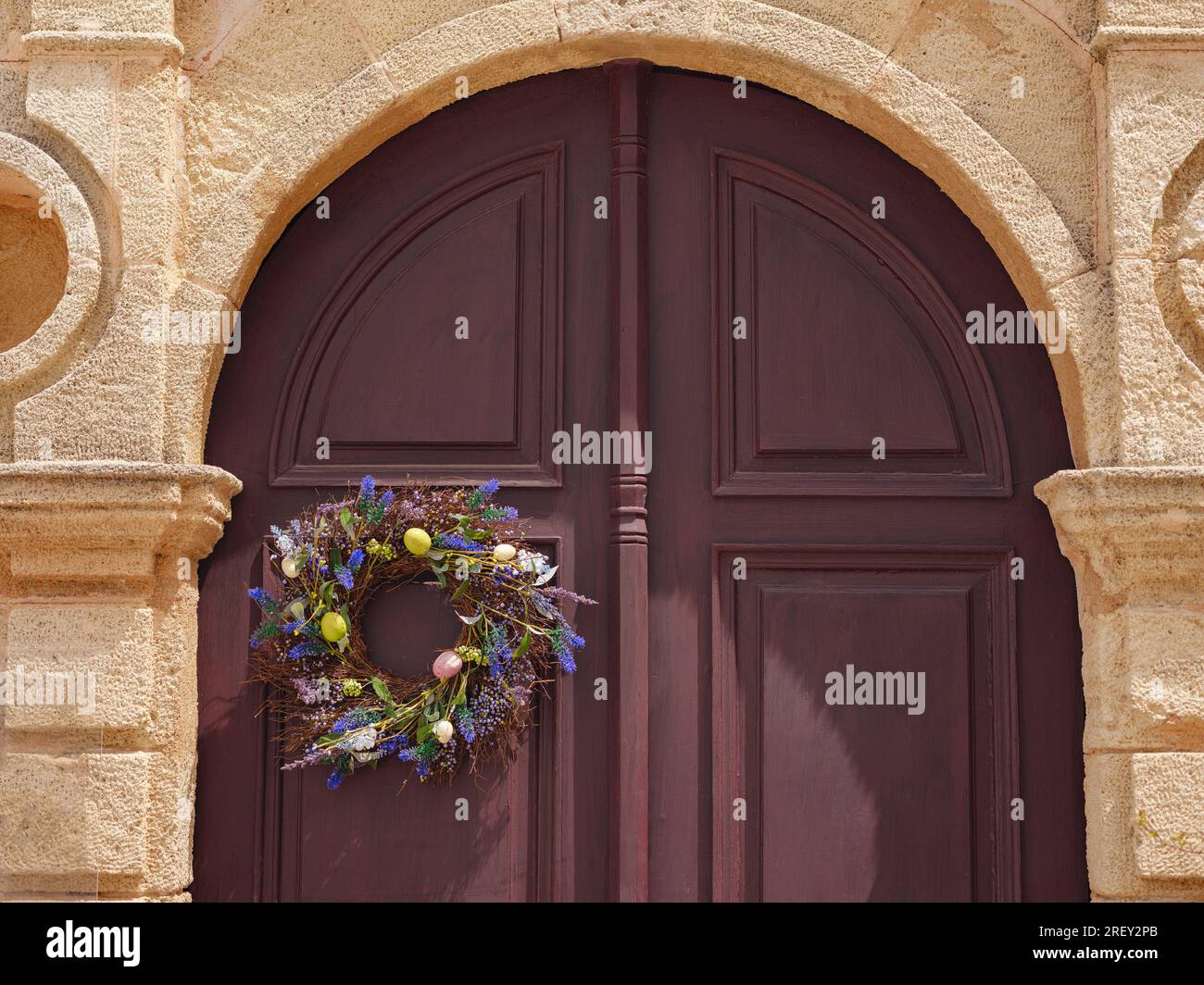 travel to city of Lindos on island of Rhodes, Greece. decoration for Easter, a wreath with flowers and Easter eggs on the door of the house Stock Photo