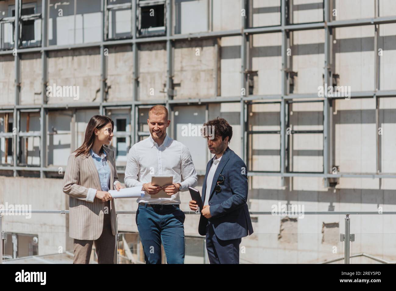 Young architecture team working together, discussing in a construction area Stock Photo