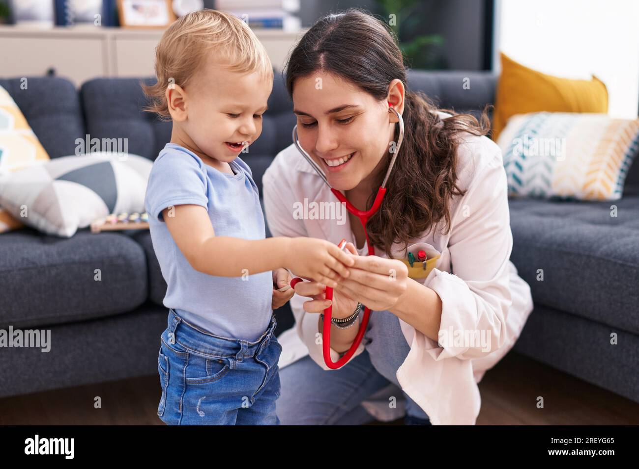 Mother and son doctor examining child at home Stock Photo - Alamy
